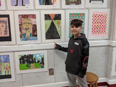 Student poses in front of his artwork