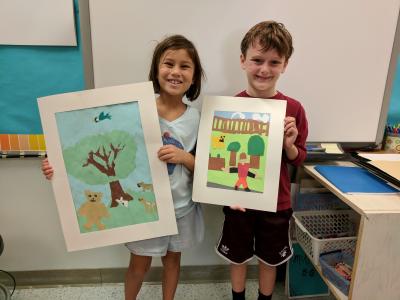 Students hold up their artwork